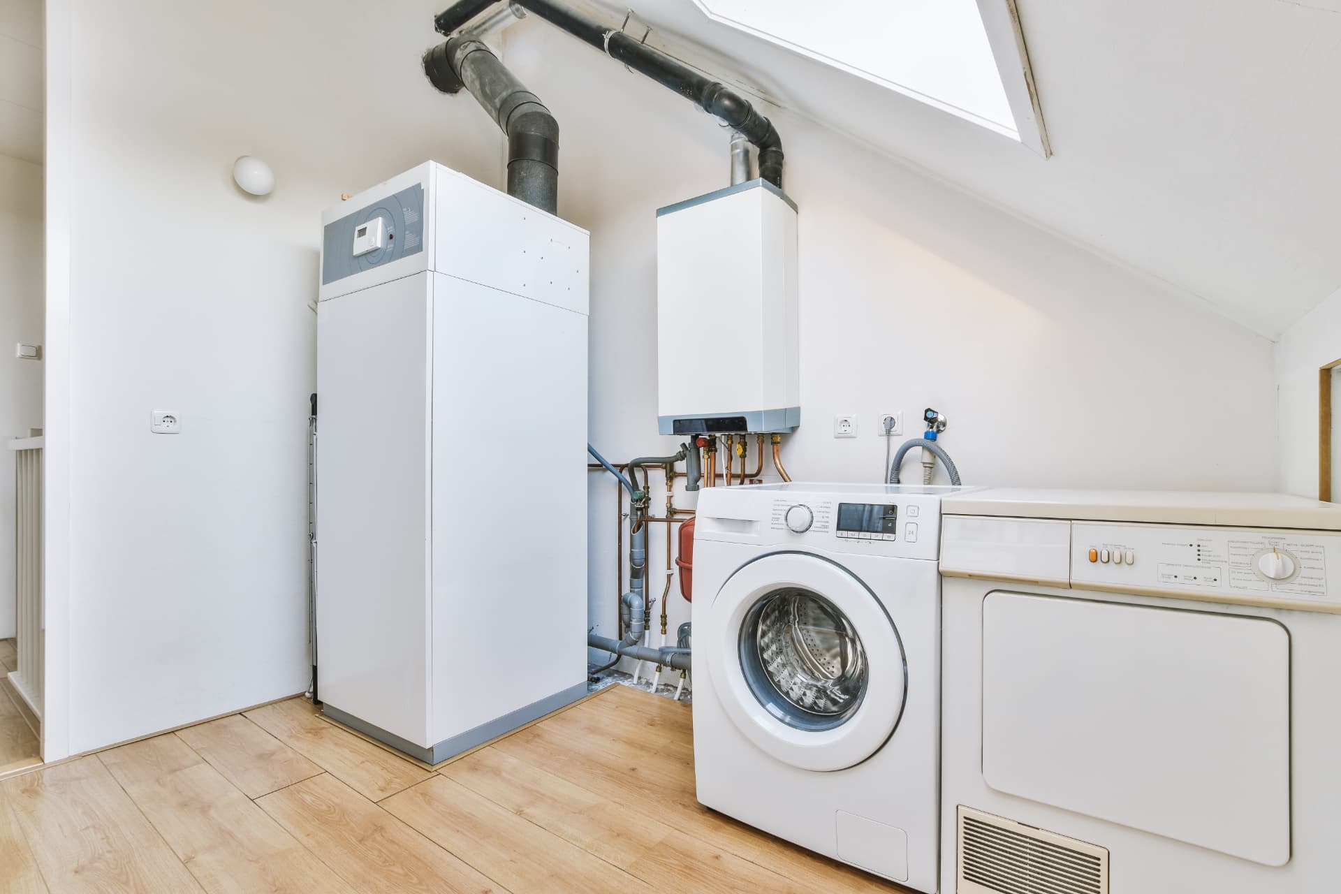 Wall mounted boiler and hot water cylinder in a bright utility room