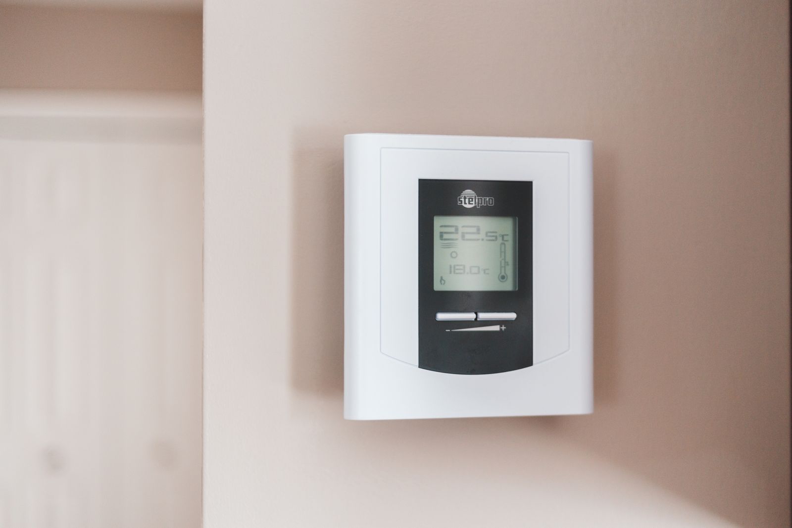 Modern digital thermostat mounted neatly on the wall of a home